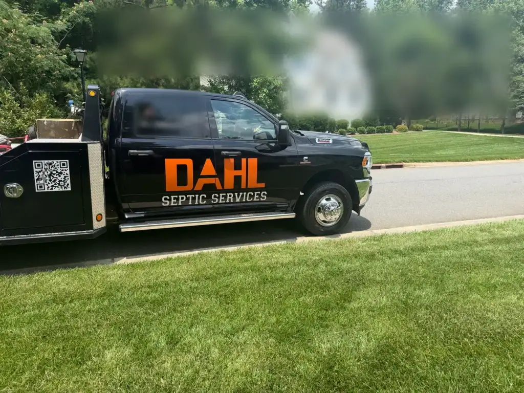Dahl Septic Services service truck parked at the curb beside a green lawn